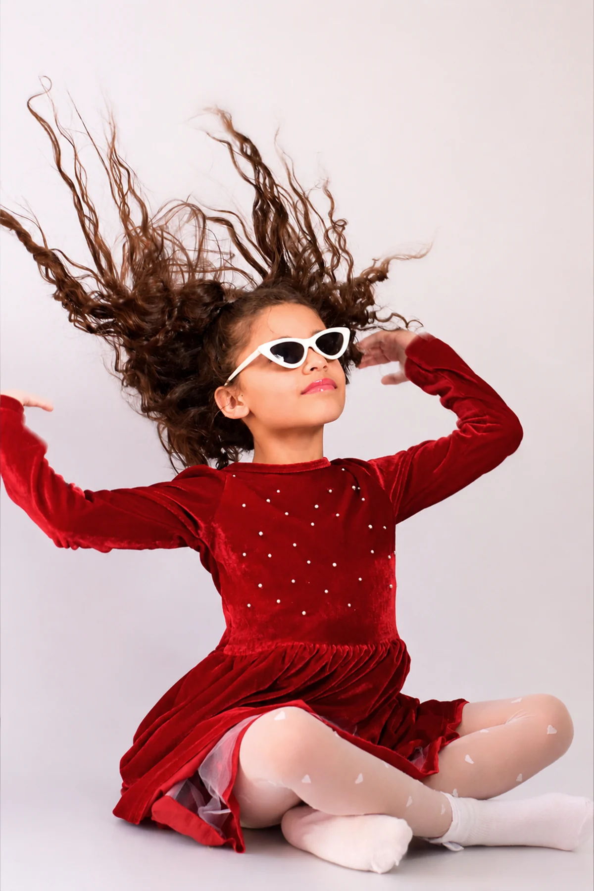 Menina brincando com óculos e o cabelo durante ensaio de aniversário
