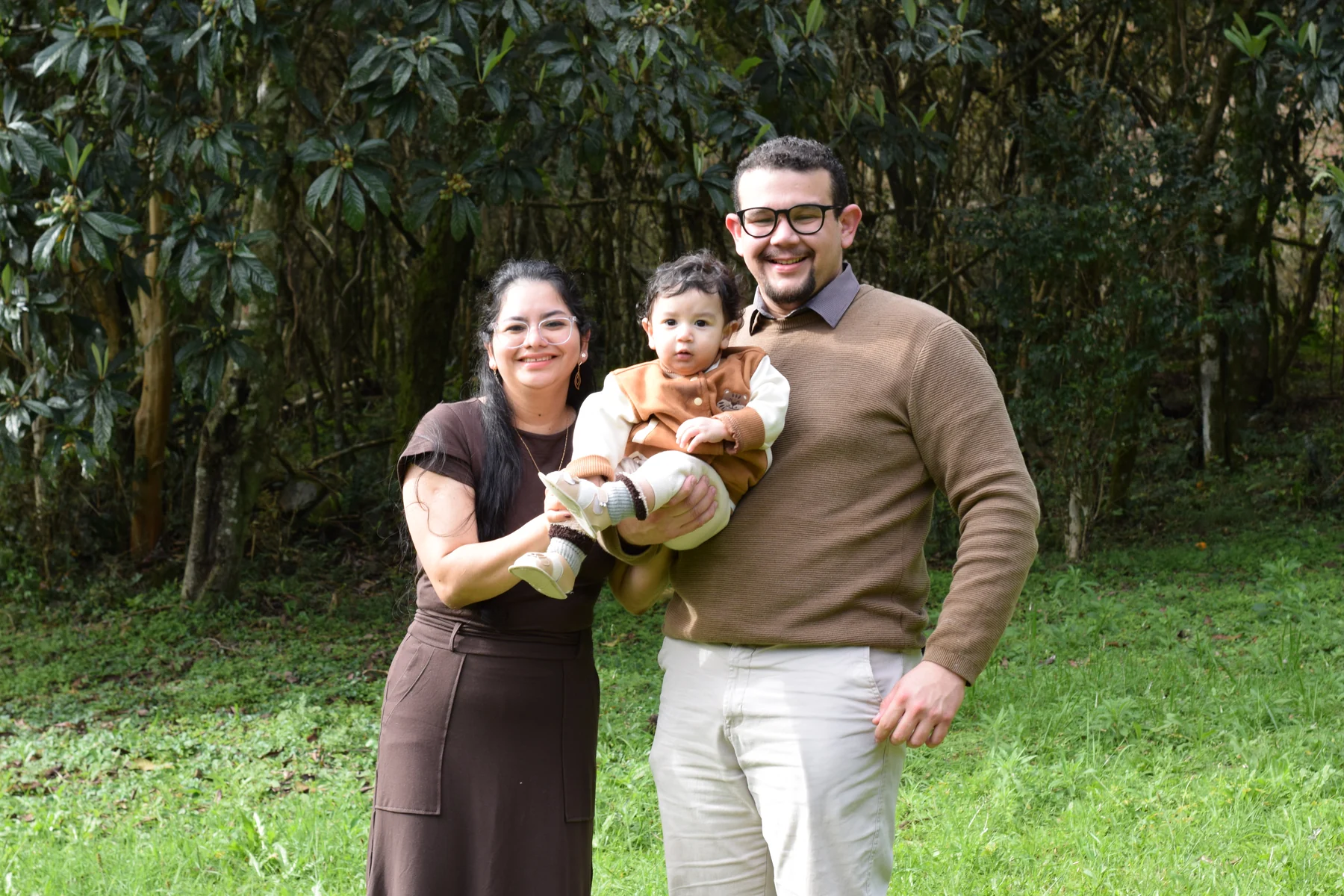 Pais com seu bebê no colo durante um ensaio em família ao ar livre